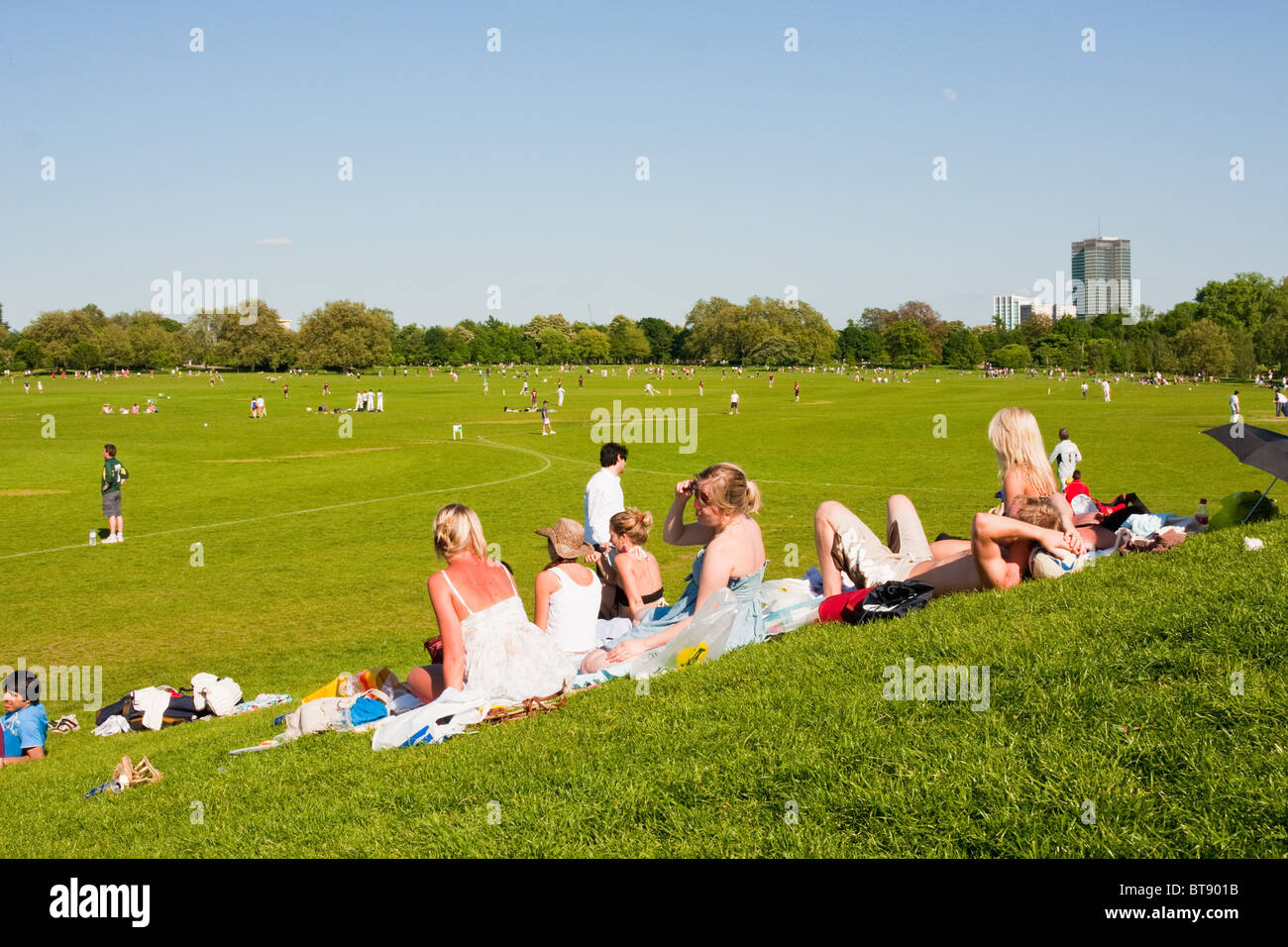 People relaxing watching cricket in Regent's Park on a sunny day in London in May 2010 Stock Photo
