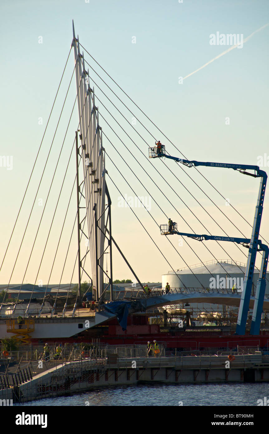 High reach access platform (cherry picker) working on a cable stayed footbridge at Salford Quays, Manchester, England, UK Stock Photo