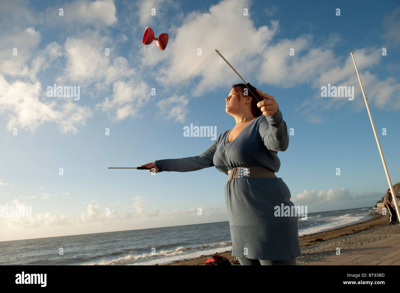 A young woman learning to use the diablo, Aberystwyth seafront Wales UK Stock Photo