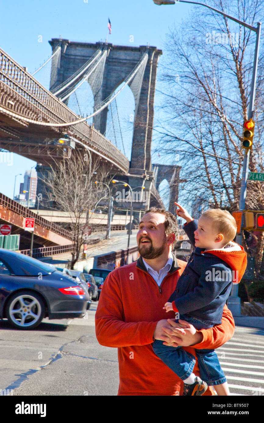 Father and son in front of the Brooklyn Bridge in Manhattan, New York Stock Photo
