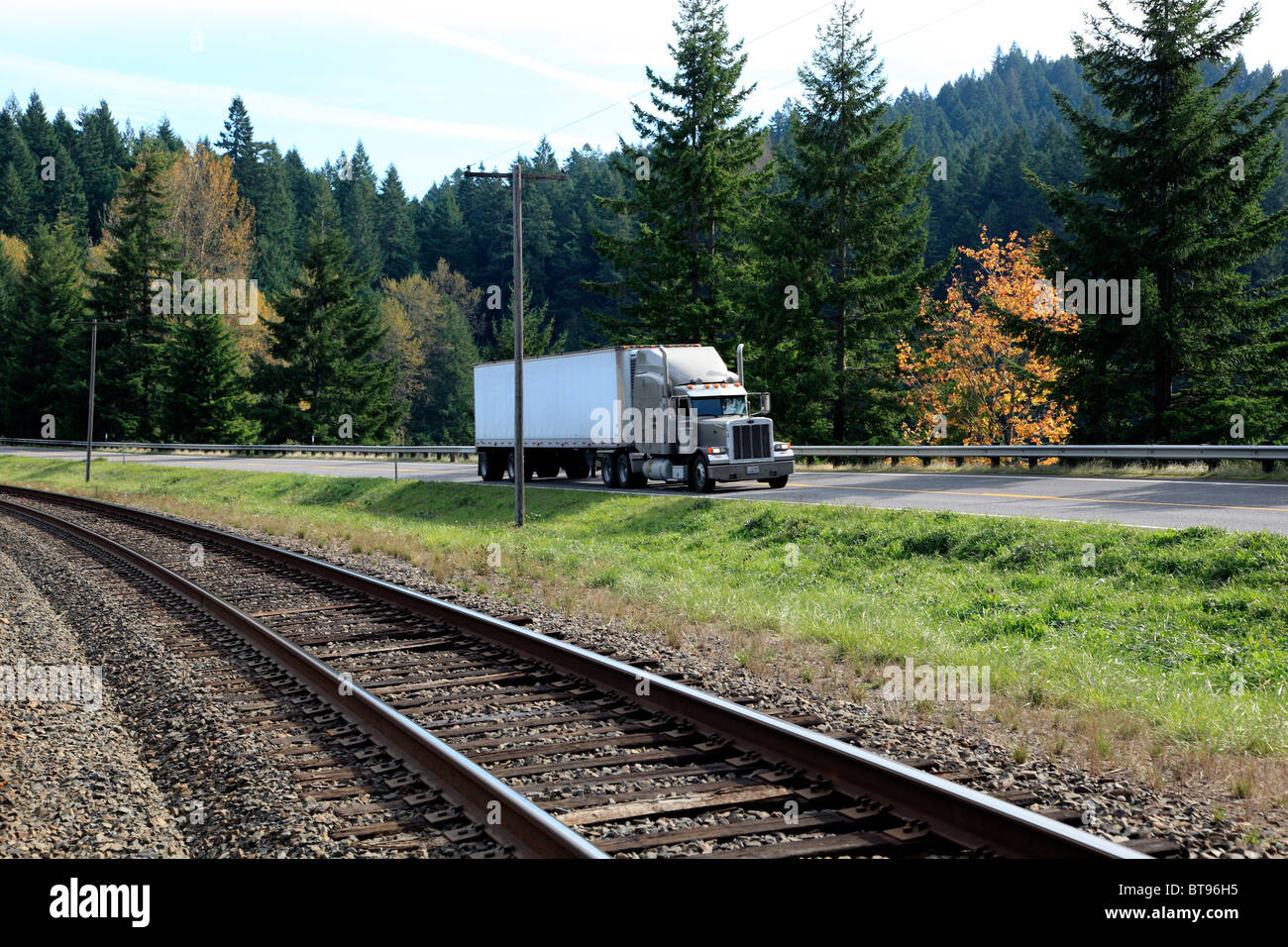 Railroad tracks lay idle as long haul trucks speed by Stock Photo Alamy
