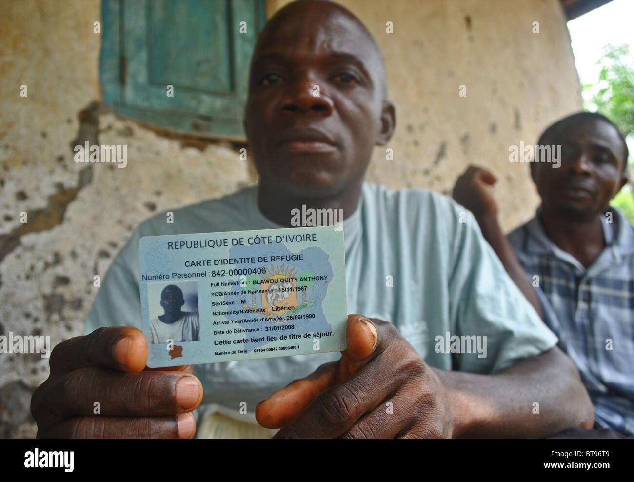 Liberian refugees display their refugee identity cards in Tabou, Ivory