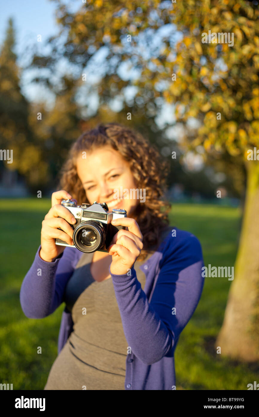 Woman holding vintage camera, portrait Stock Photo