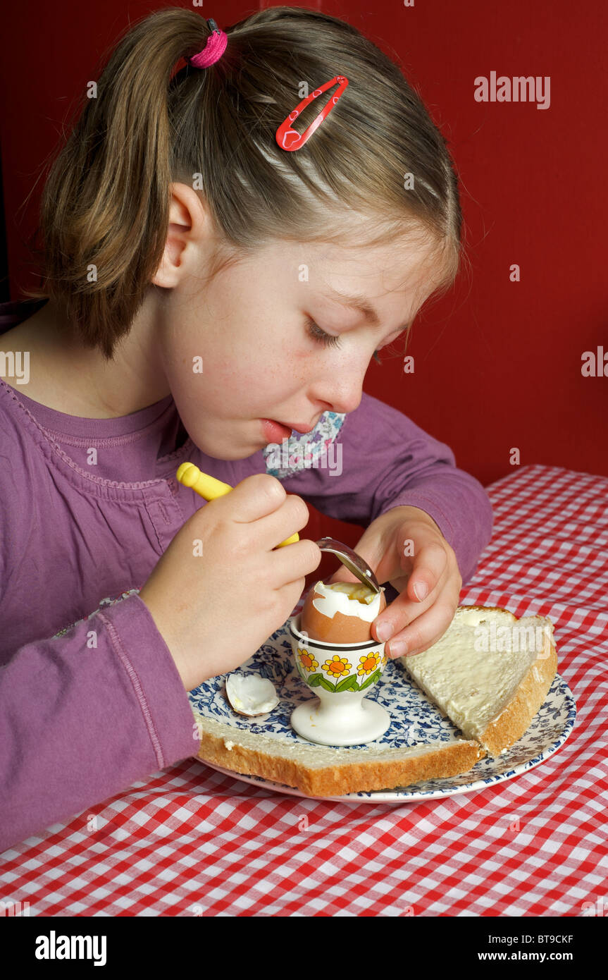 Young girl eating boiled egg for breakfast Stock Photo Alamy