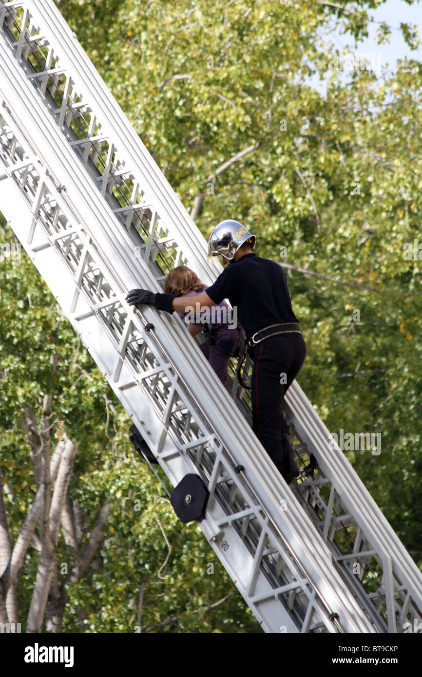 Fireman and child on a ladder at a rescue service recruitment and information day in Paris Stock Photo