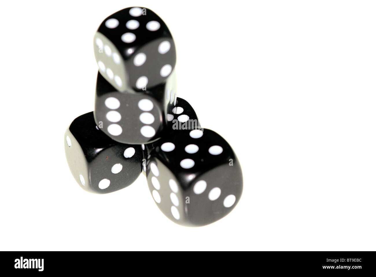 A number of black dice roughly stacked on a white background Stock Photo