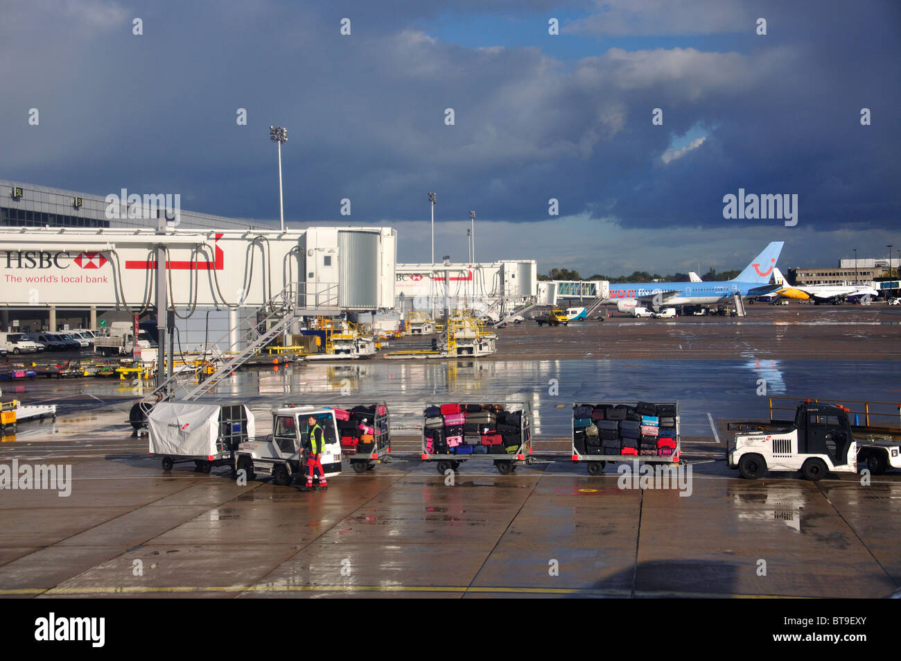 Luggage trollies on tarmac, Gatwick Airport, North Terminal, Gatwick Airport, Crawley, West Sussex, England, United Kingdom Stock Photo