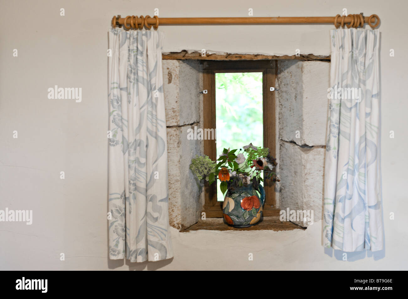 A window with curtains and a vase of flowers Stock Photo Alamy