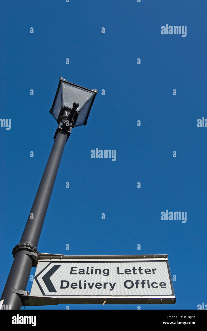 direction sign for ealing letter delivery office fixed to a victorian style street lamp, in ealing, west london, england Stock Photo