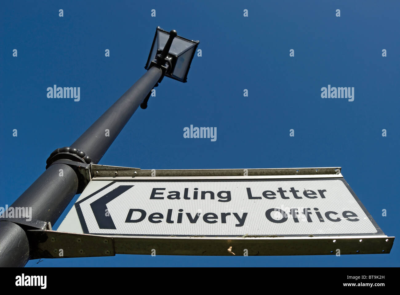 direction sign for ealing letter delivery office fixed to a victorian style street lamp, in ealing, west london, england Stock Photo