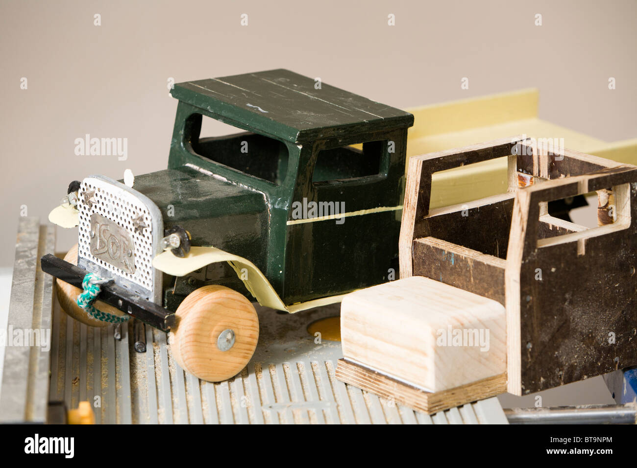 Wooden toy trucks, one complete and one in the making. Stock Photo