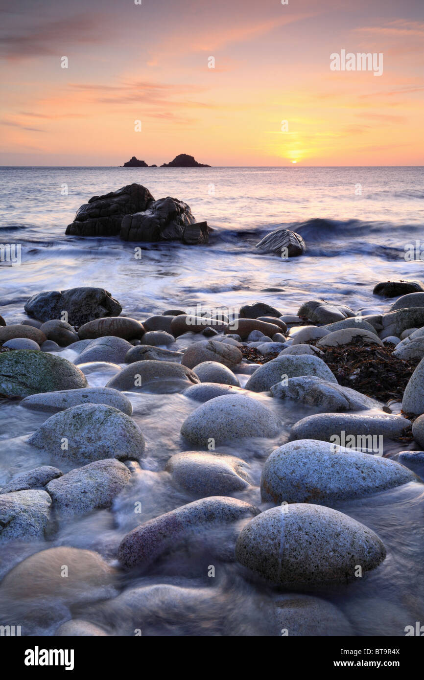 The Brison's Rocks captured from boulder strewn Porth Nanven Cove near St Just in Cornwall Stock Photo