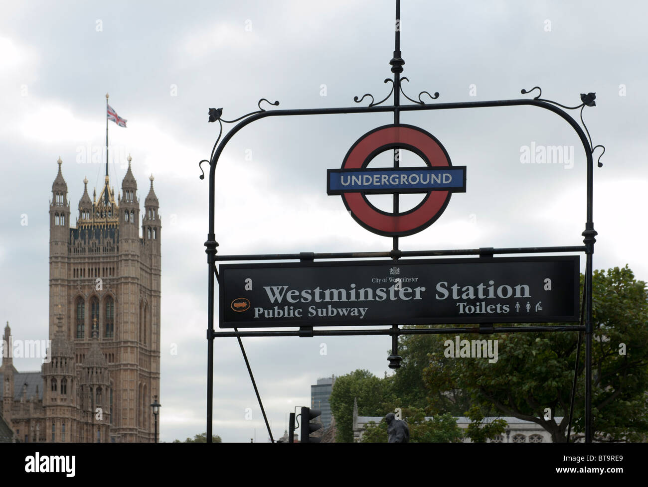 Entrance to Westminster underground, with the Victoria Tower of the Houses of Parliament in the background Stock Photo