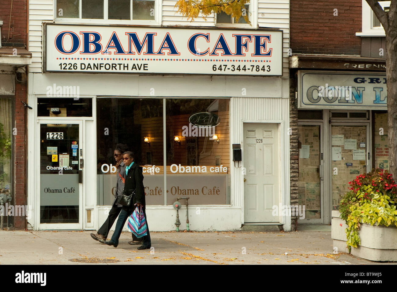 Two Women Stroll By The Obama Cafe On Danforth Street In Toronto Stock Photo Alamy