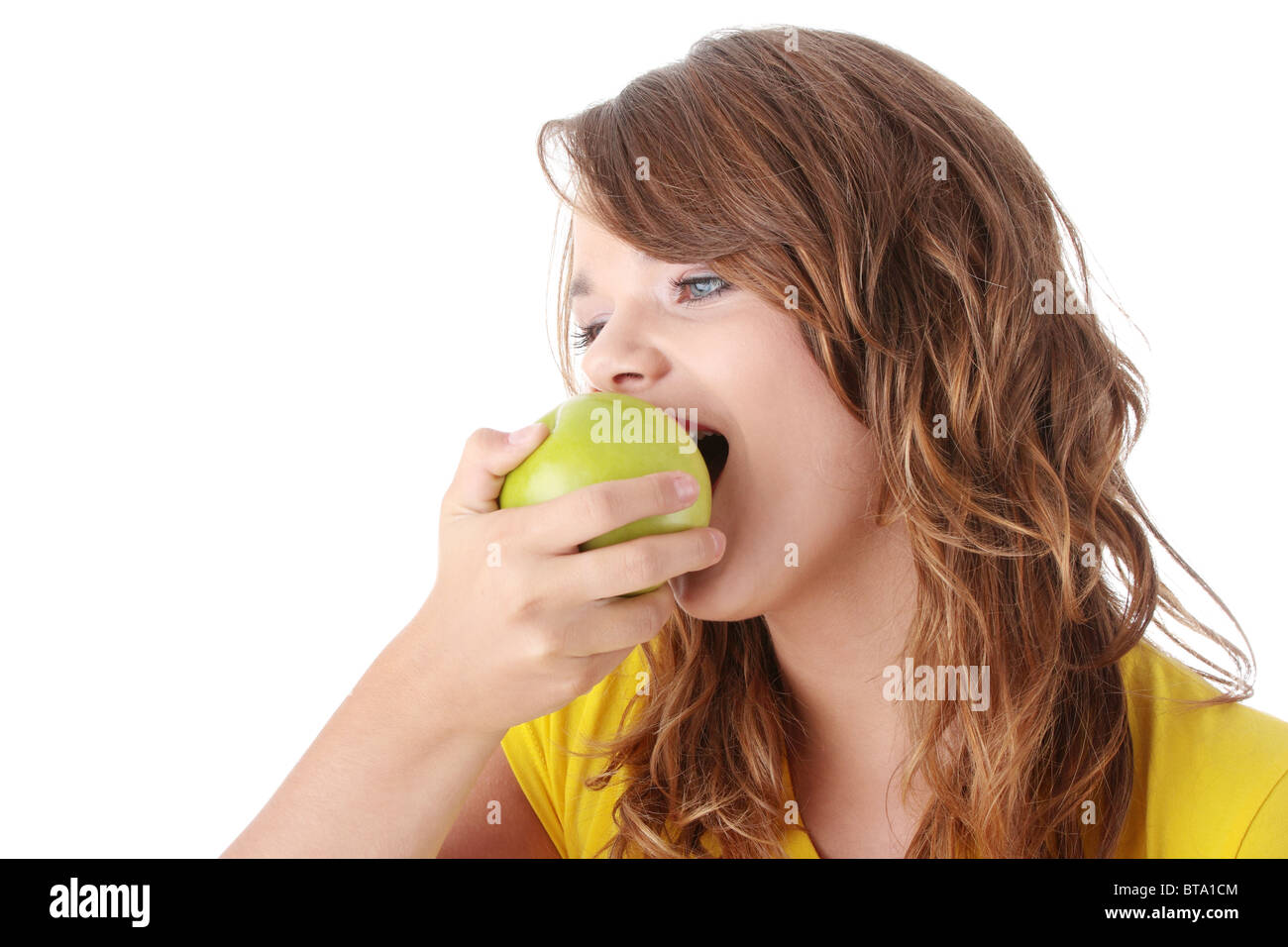 Teen girl eating grean apple isolated on white background Stock Photo