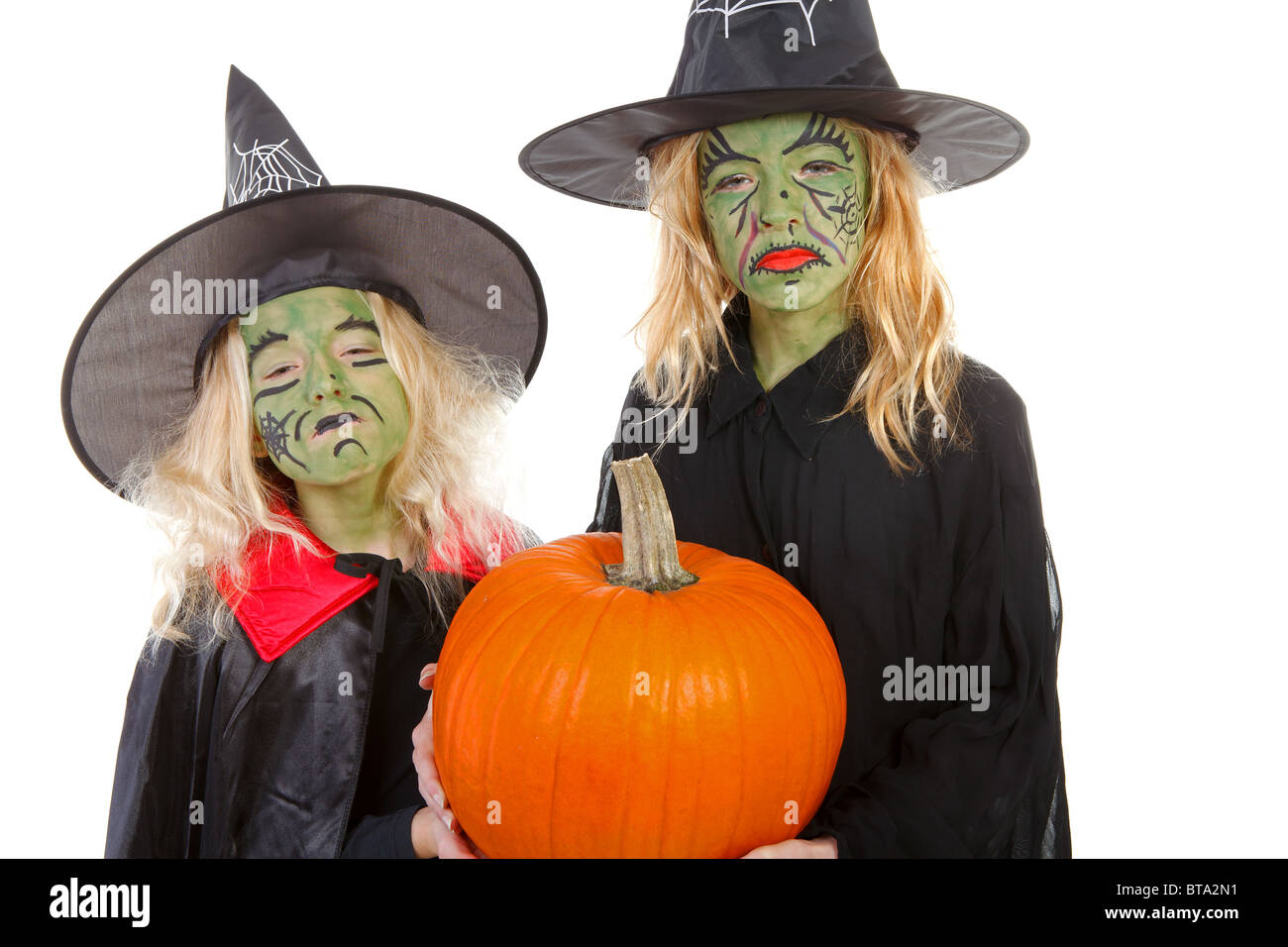 Scary green witches for Halloween with pumpkin over white background Stock Photo