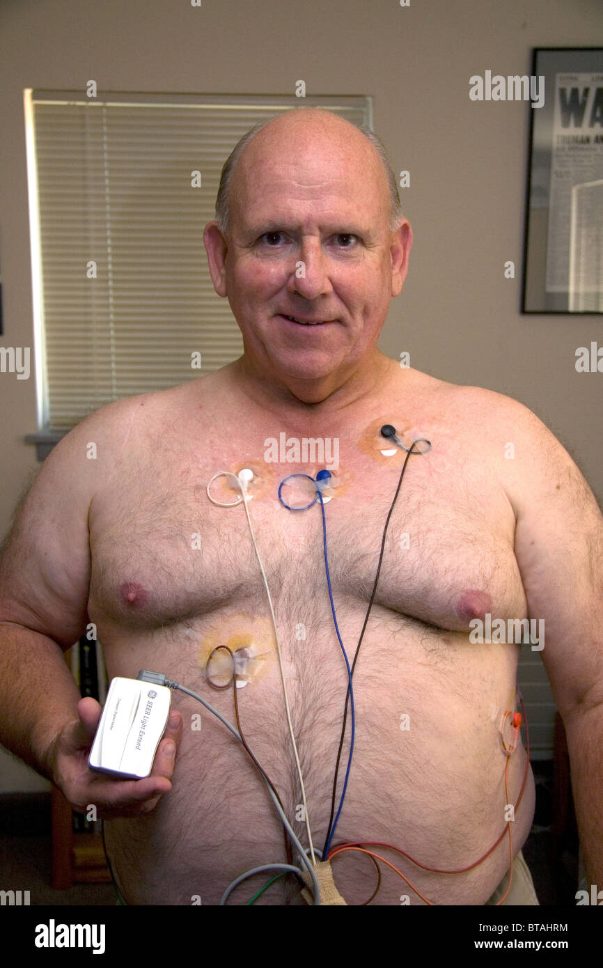 American man wearing a Holter monitor used for monitoring the heart for cardiac arrhythmias. MR Stock Photo