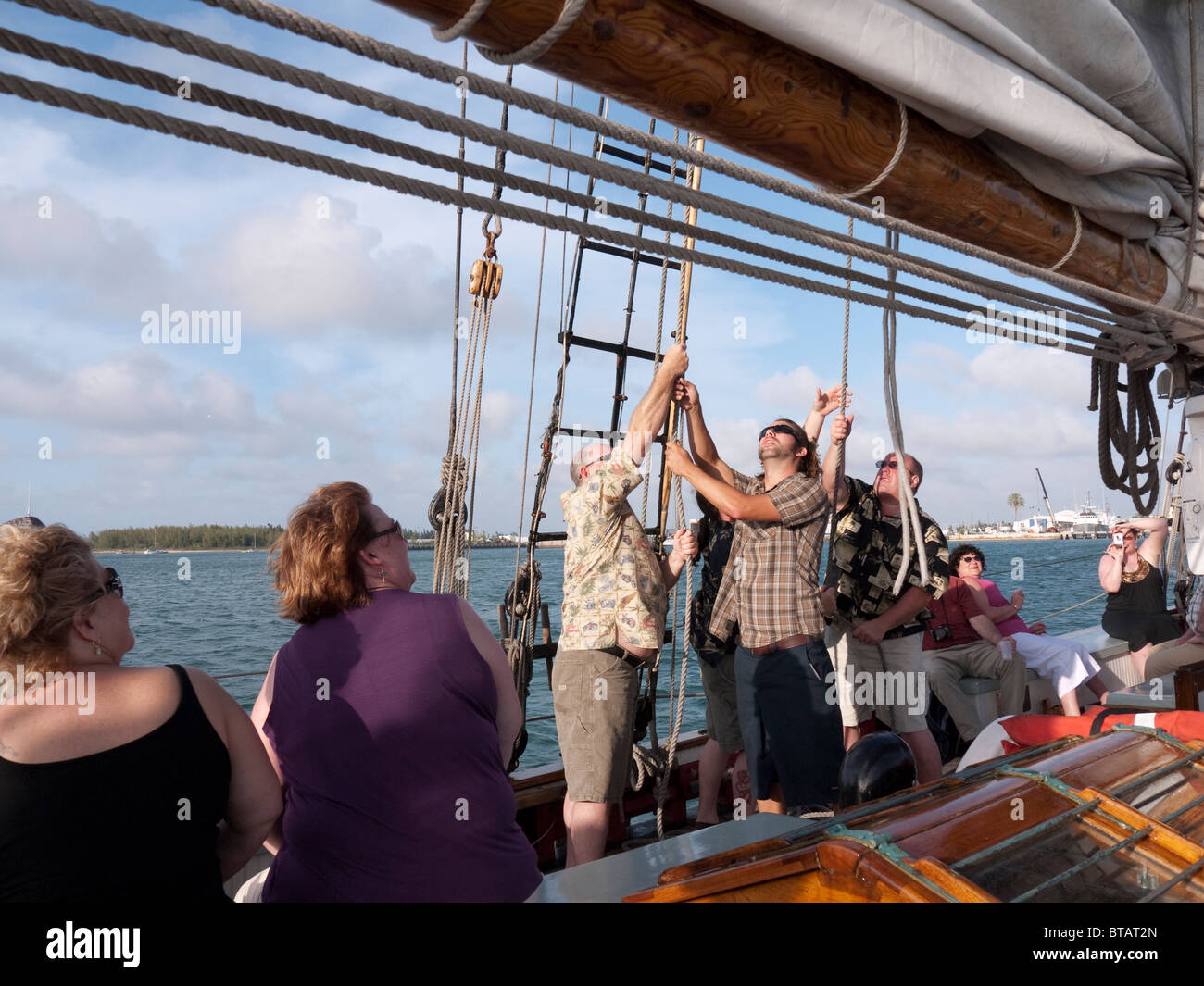 Passengers helping to hoist the sail on the Sailing Ship the Schooner