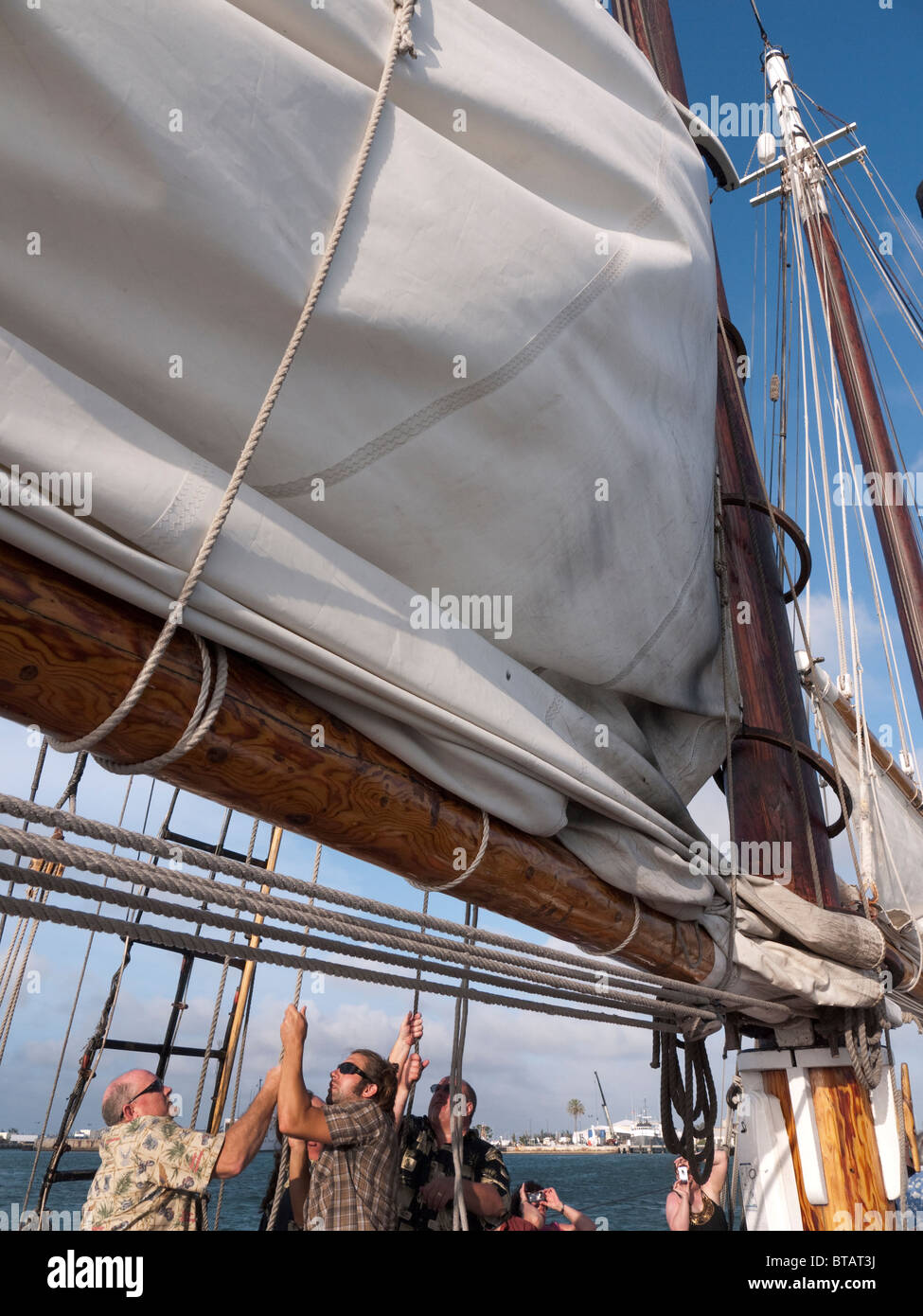 Passengers helping to hoist the sail on the Sailing Ship the Schooner