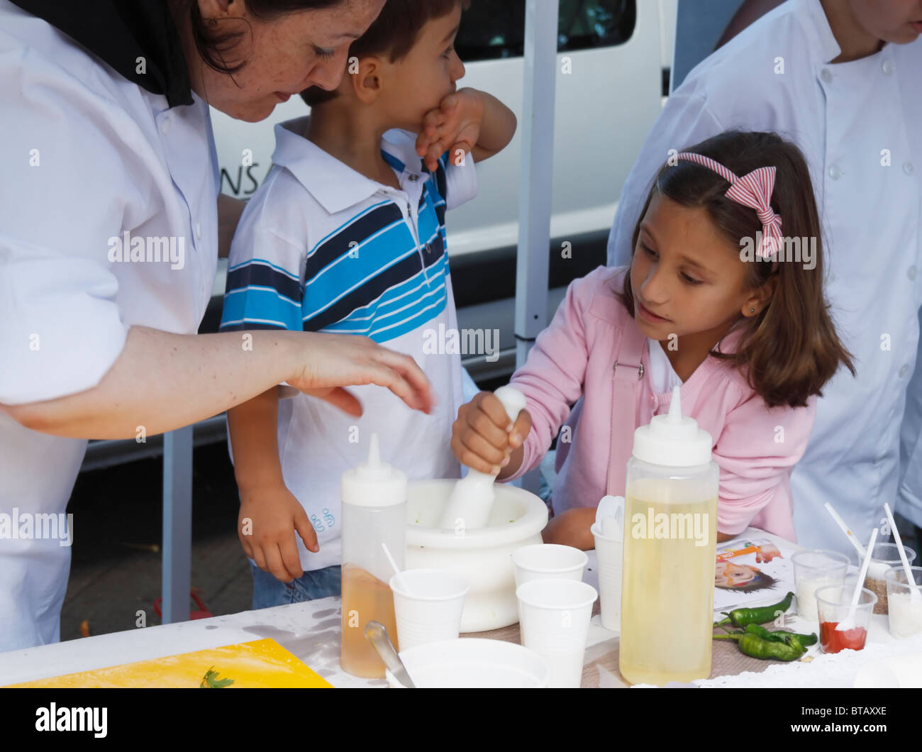 Spanish boy and girl learning how to make Mojo sauce at competition to