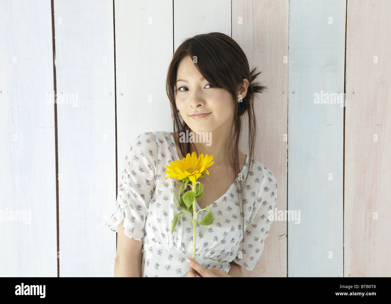 Young woman holding a sunflower Stock Photo - Alamy