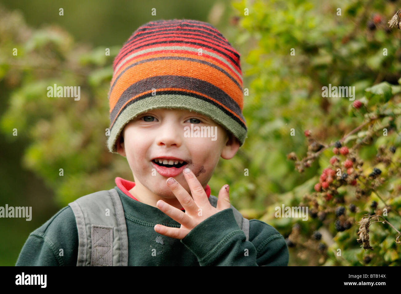 A boy eating blackberries on a nature walk at Conwy RSPB reserve Stock Photo