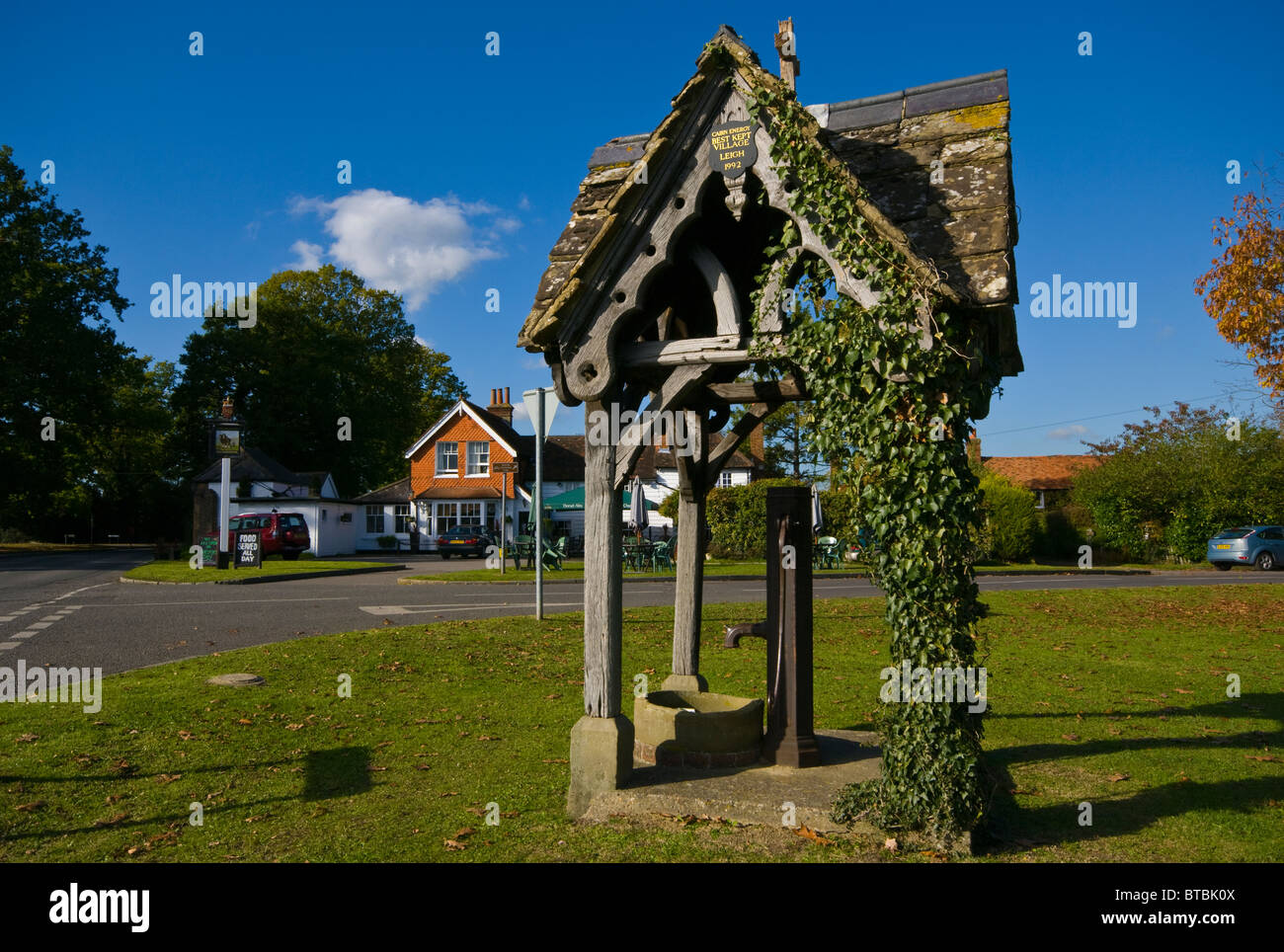 The Old Village Pump On Leigh Green With The Plough Pub In The Background Surrey England Stock Photo