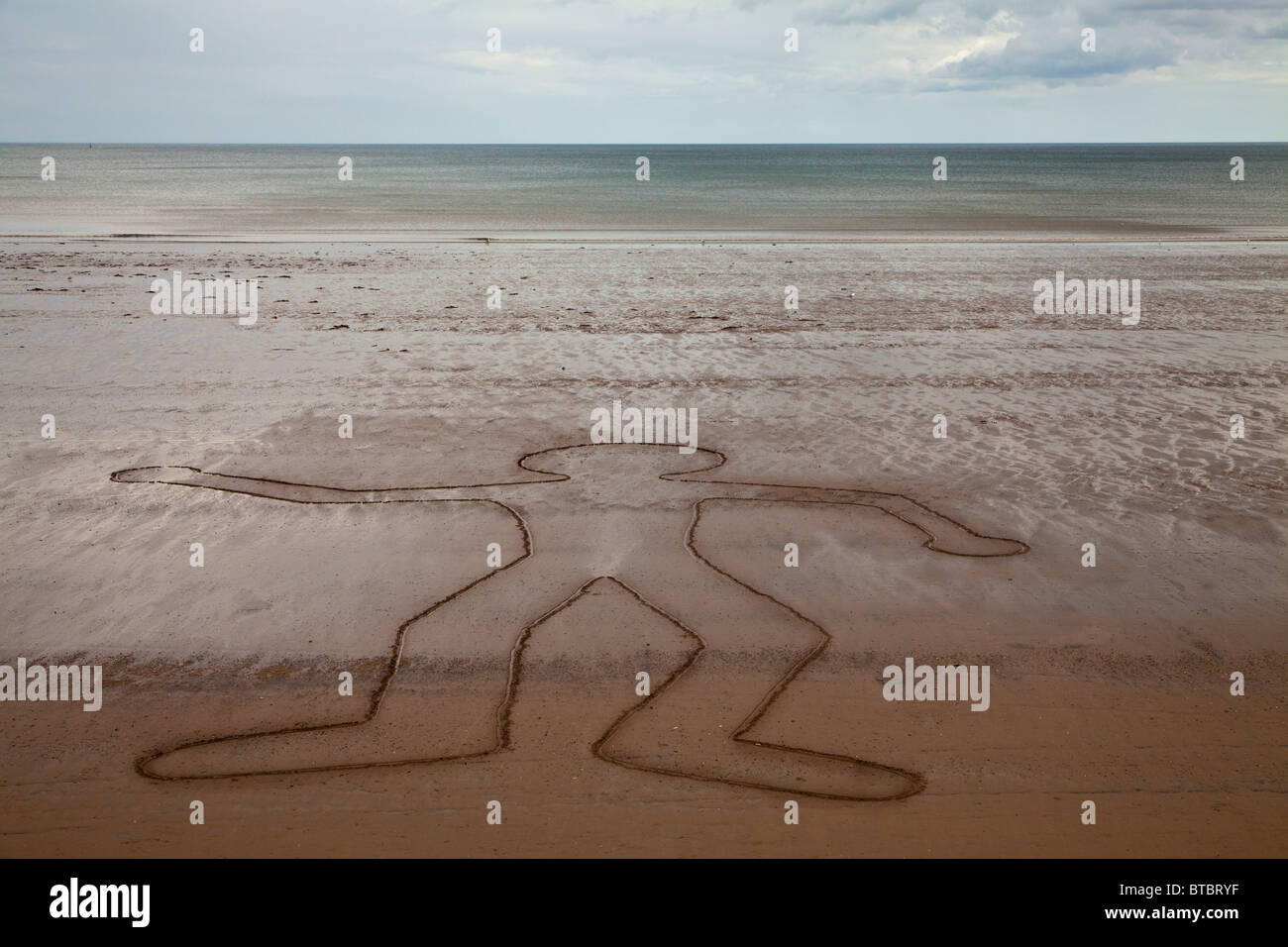 Outline drawing of dancing man on beach at Filey, North Yorkshire. Stock Photo