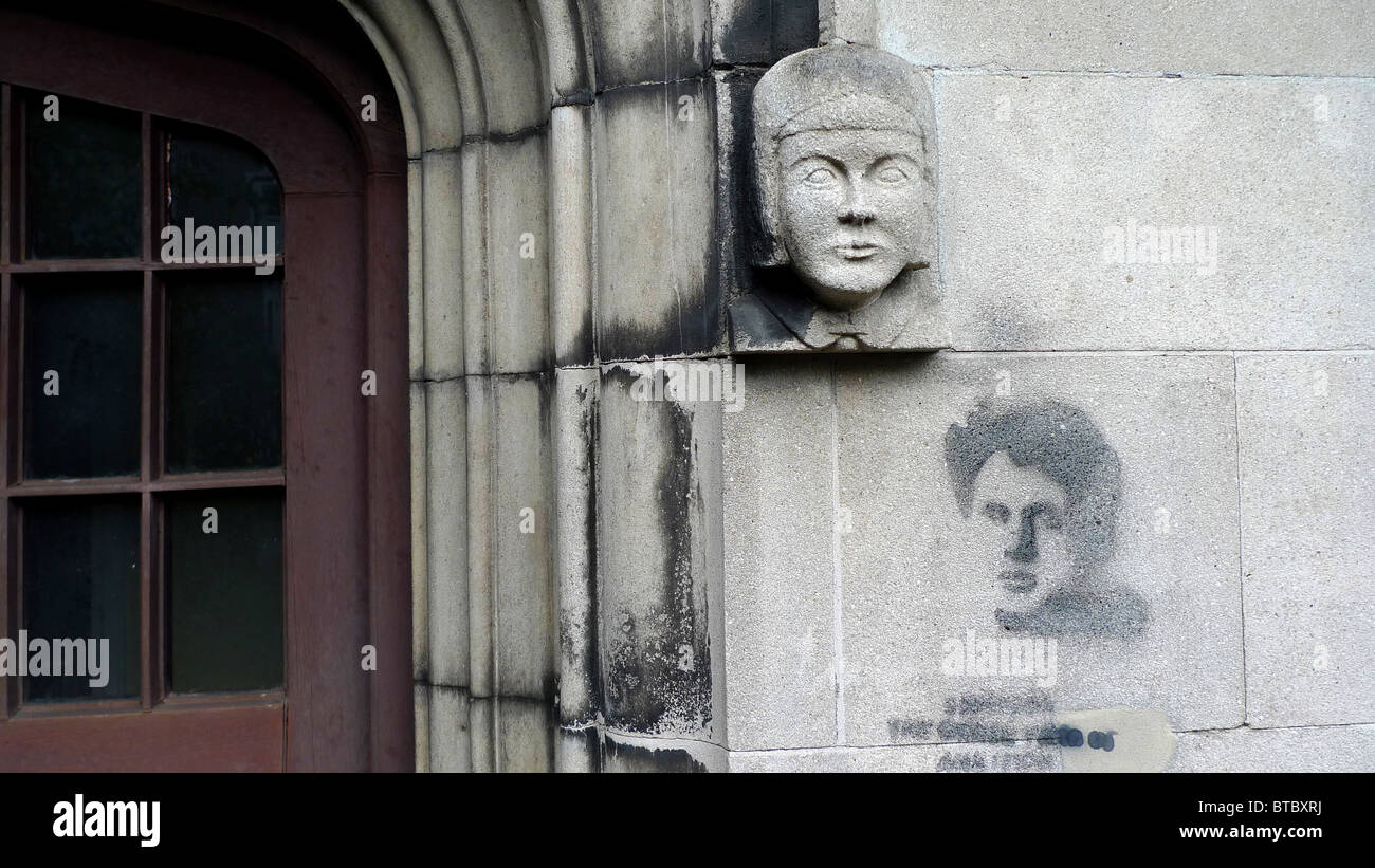 Stone carving on gothic archway with graffiti stencil mimic, Swansea