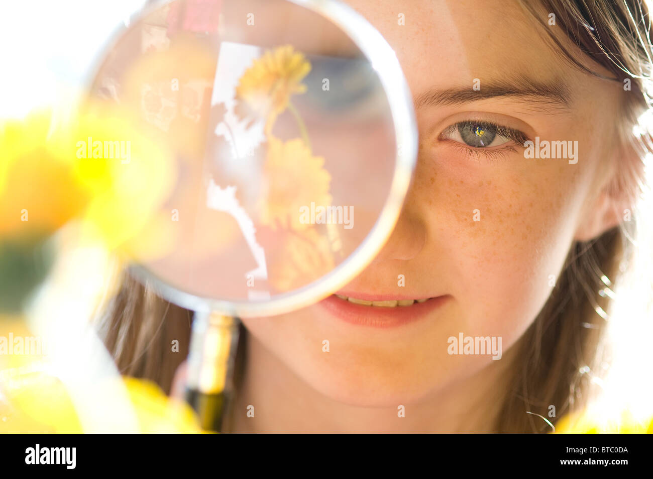 young female looking at flower through magnifying glass Stock Photo Alamy