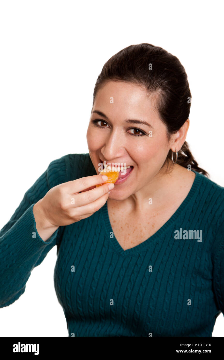 Beautiful happy woman eating a slice of mandarin orange fruit full of vitamin C for a healthy diet, isolated. Stock Photo