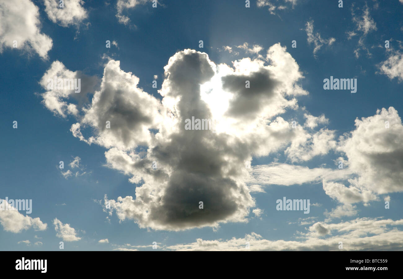 Cloud formation in the shape of an Angel or a map of the UK with sunlight behind Stock Photo