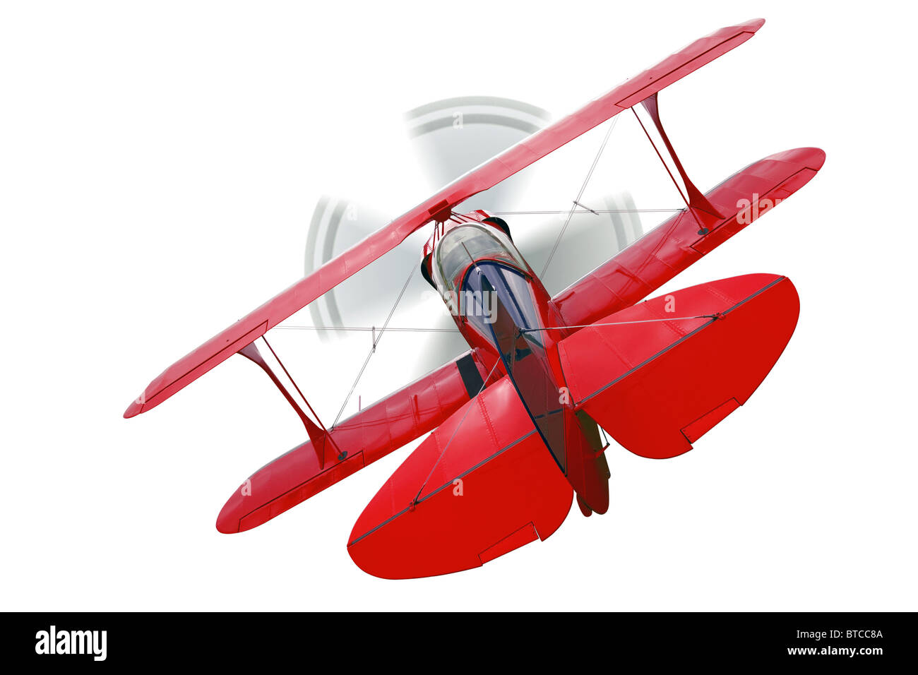 A red biplane, rear view with propeller in motion, isolated on a white background. Stock Photo