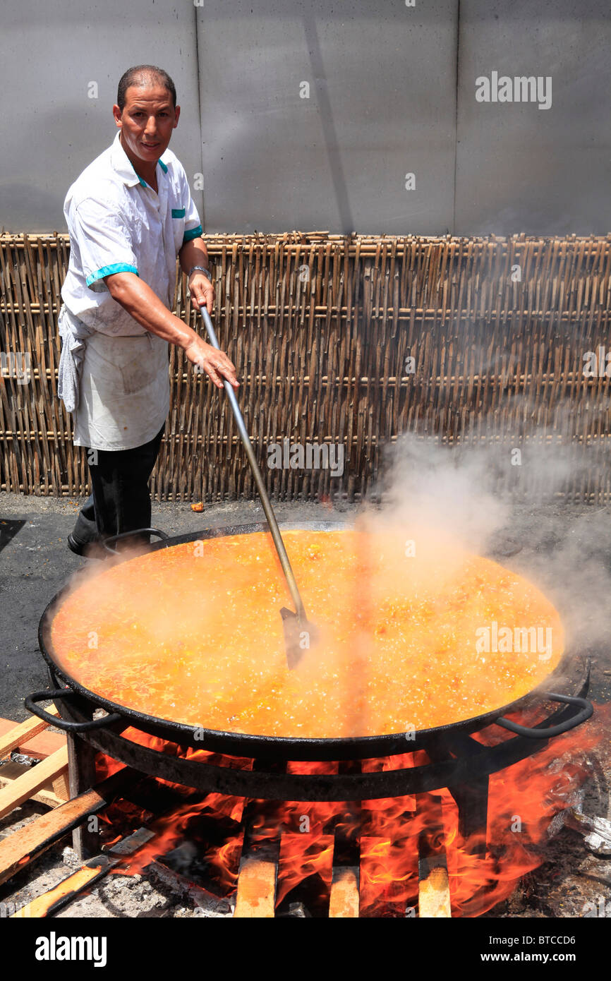 A chef preparing a giant paella at Burriana Beach in Nerja on the Costa del Sol in the province of Malaga, Spain Stock Photo