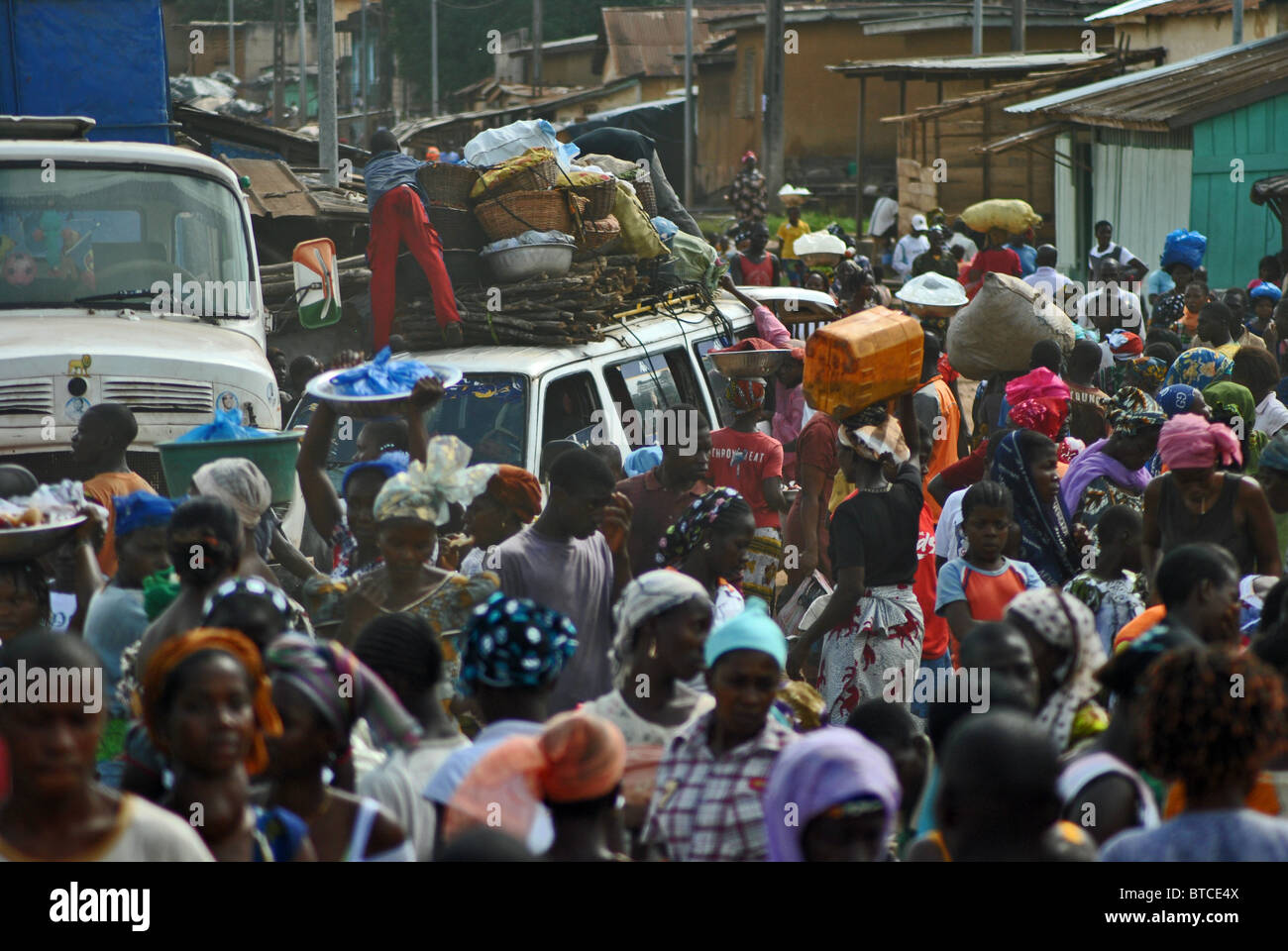 Crowds of people and vehicles on a road in Man, Ivory Coast, West Africa Stock Photo