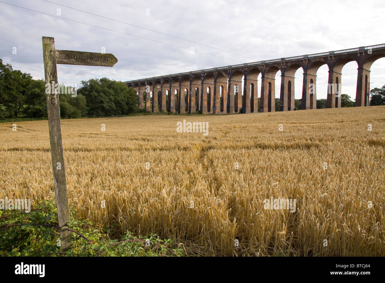Public footpath sign with the Ouse Valley Viaduct in the background. Balcome, West Sussex England Stock Photo