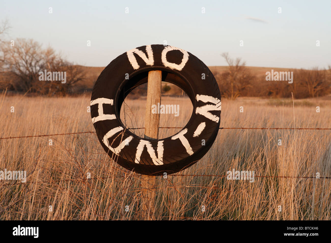 'No Hunt-N' painted on a tire hung on a fence in rural Nebraska. Stock Photo