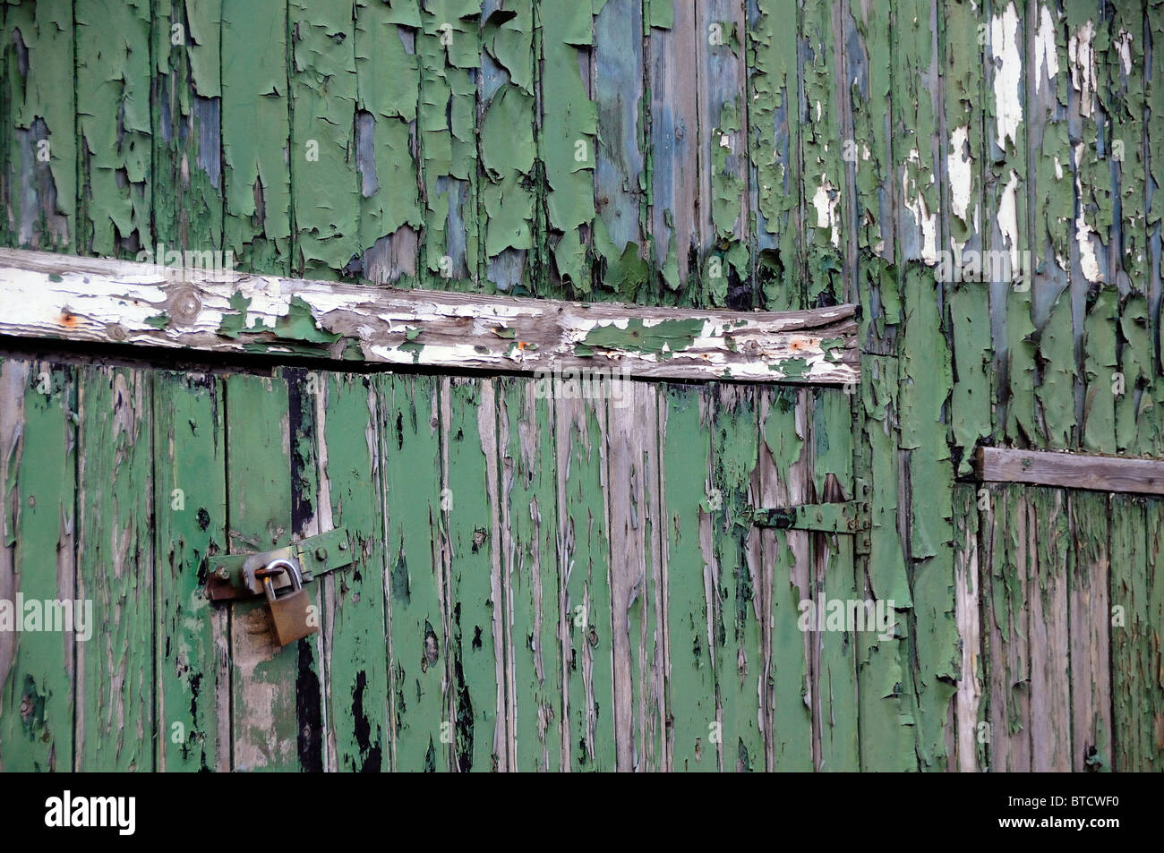 green paint peeling off wooden doors Stock Photo