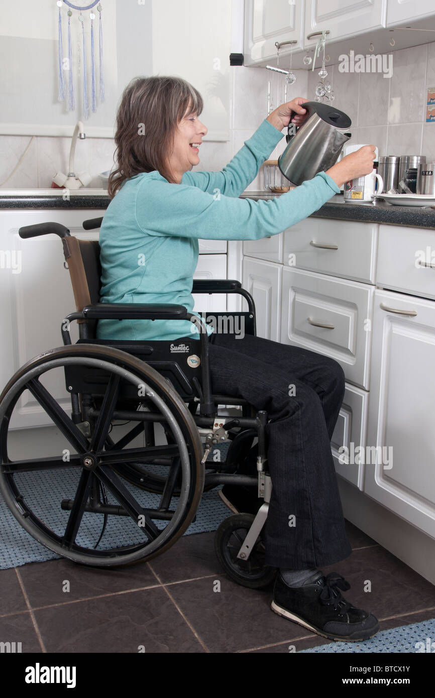 https://c8.alamy.com/comp/BTCX1Y/disabled-woman-in-wheelchair-preparing-food-in-kitchen-BTCX1Y.jpg