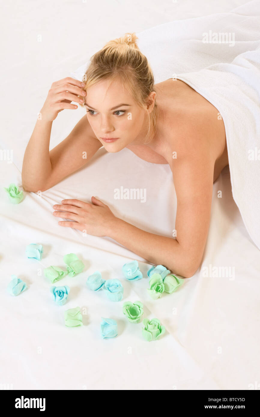Beautiful girl relaxing in spa surrounded by aromatherapy items Stock Photo