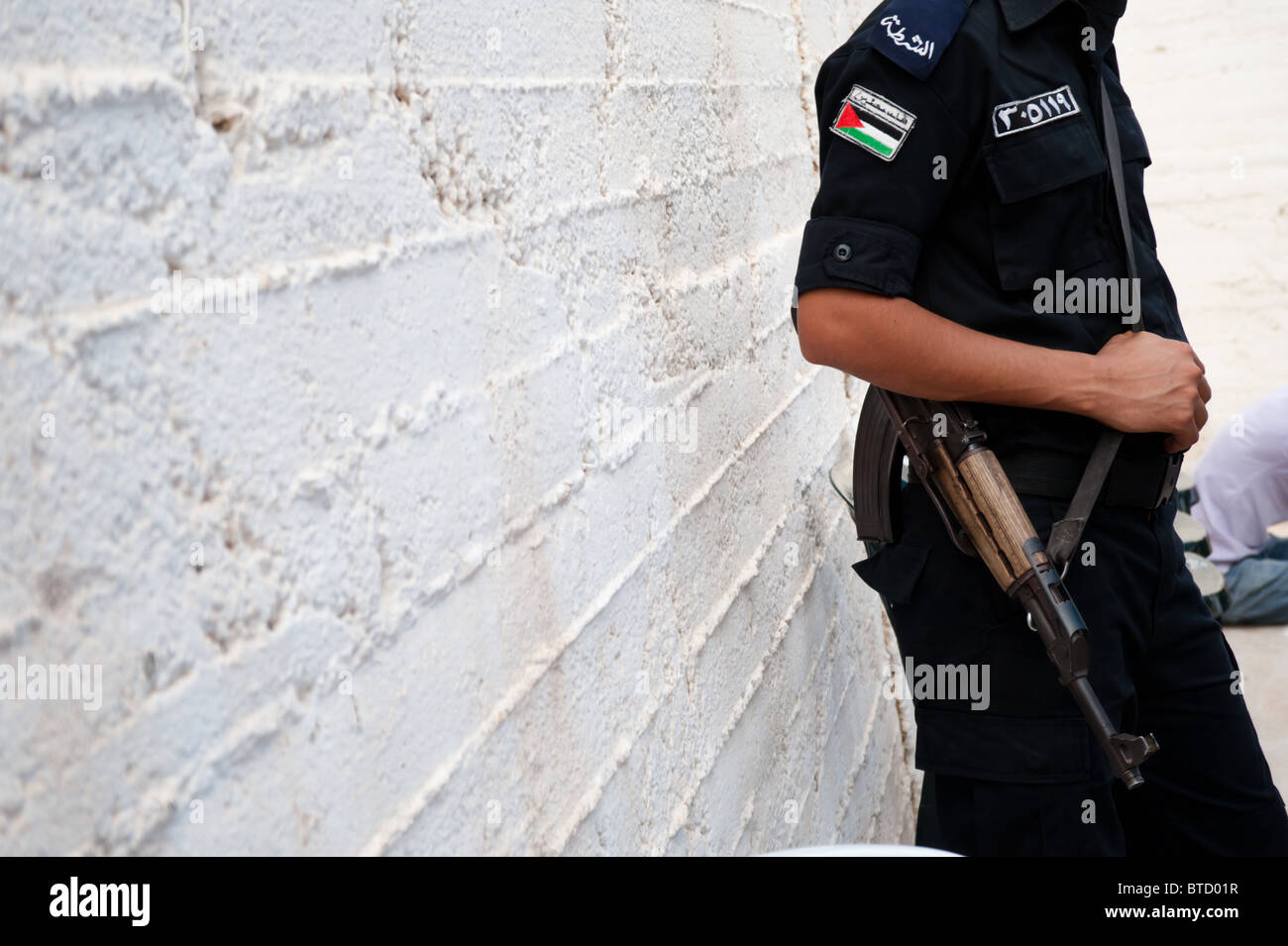 A Palestinian Authority policeman armed with a Kalashnikov rifle stands guard  in the West Bank town of Taybeh. Stock Photo
