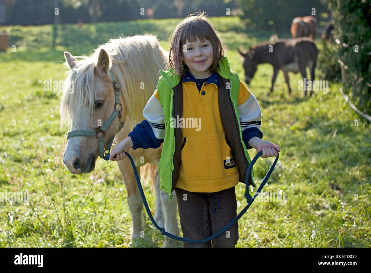 portrait of a little girl walking with a pony Stock Photo