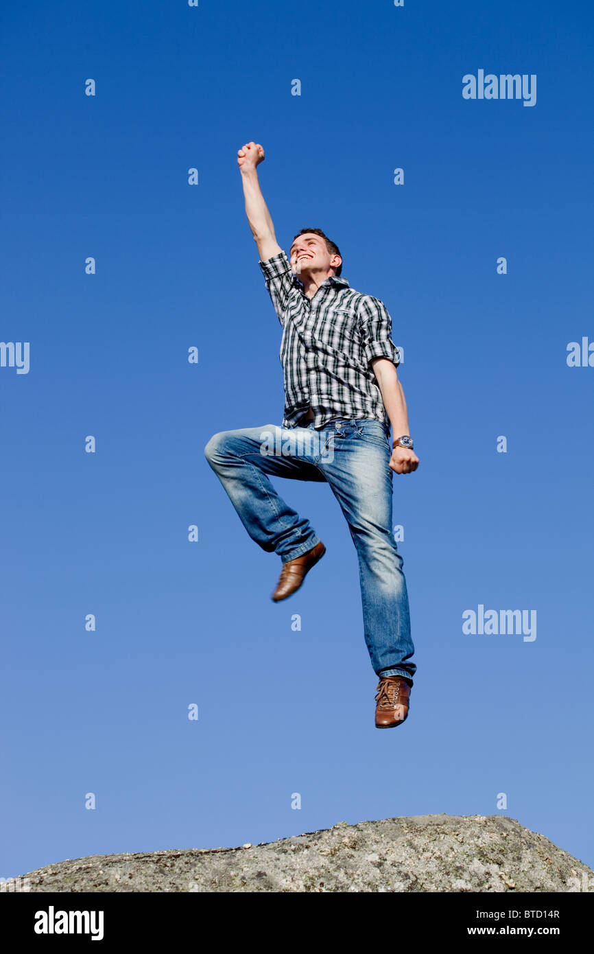 Young Happy Man With A Big Jump On Top Of A Rock Stock Photo Alamy