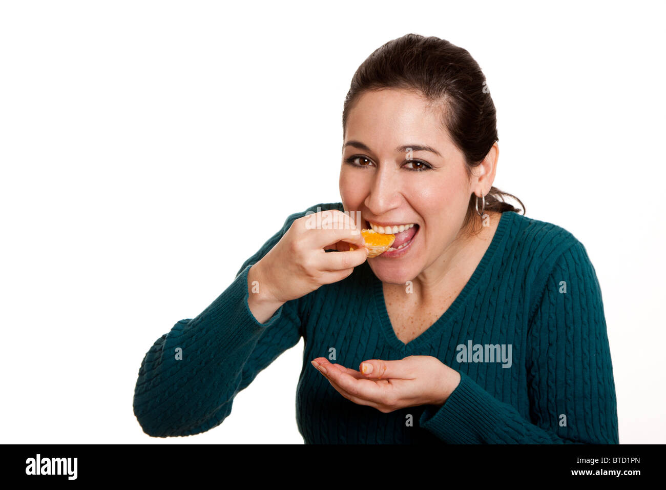 Beautiful happy woman eating a slice of juicy mandarin orange fruit full of vitamin C for a healthy diet, isolated. Stock Photo