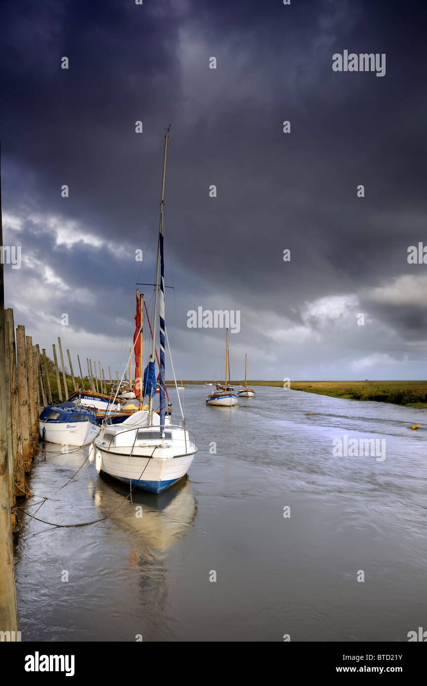 A storm approaching sailing boats moored at Blakeney Stock Photo