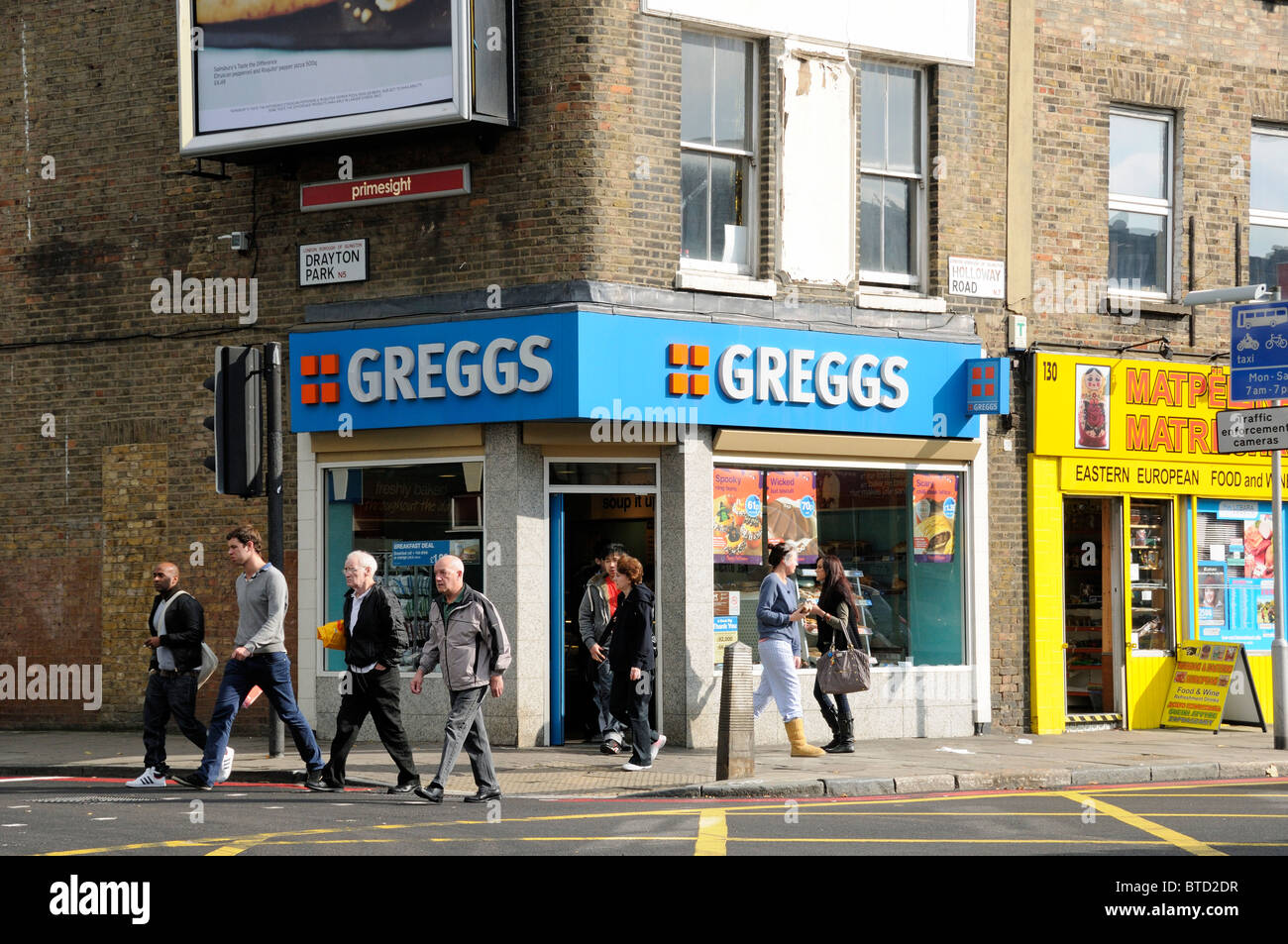 People passing Greggs Bakery, Corner of Holloway Road and Drayton Park