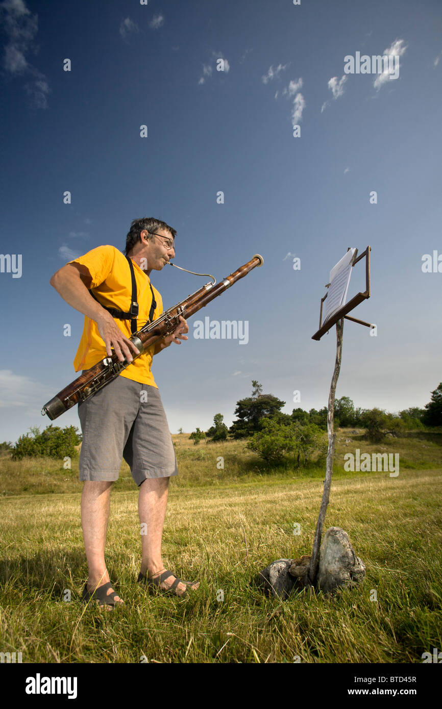 A man playing the bassoon in open air (Auvergne France). Joueur de