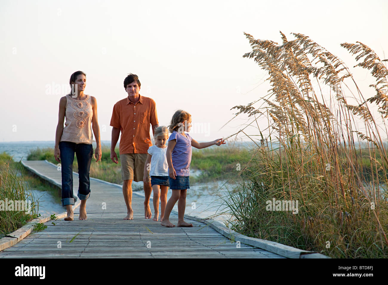 Family walking on beach walkway Stock Photo