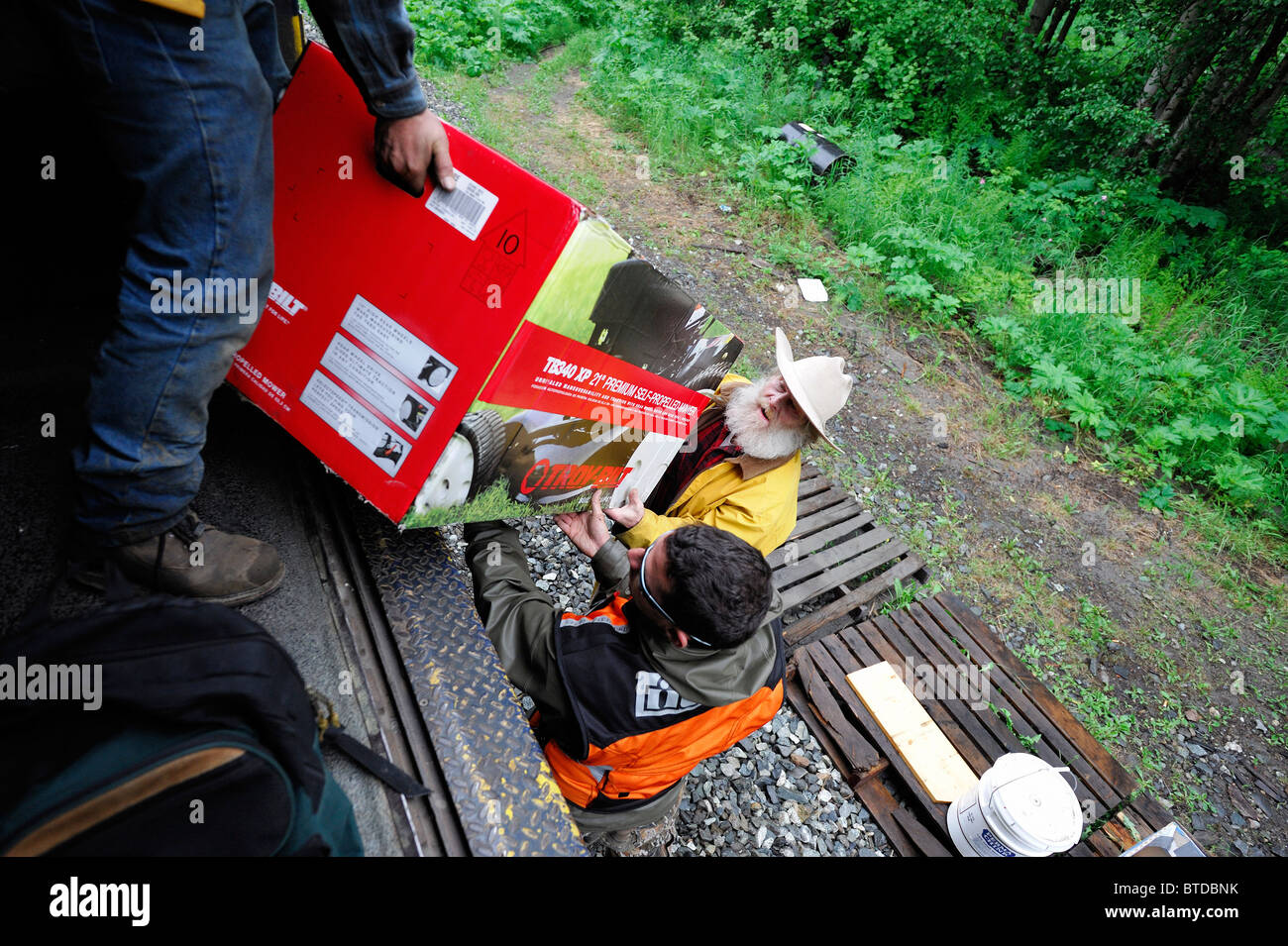 Alaska Railroad conductor helps a homestead passenger unload at his