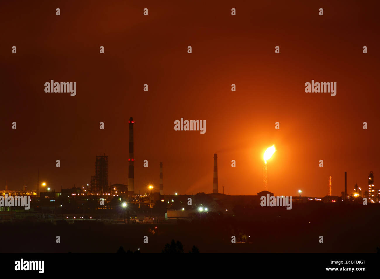 view on petrochemical factory with flame at night Stock Photo